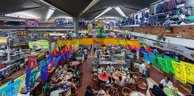 2026년 6월 15일(현지시간) 멕시코 할리스코주 과달라하라의 산 후안 데 디오스 시장(Mercado San Juan de Dios). 1958년 개장한 이 시장은 면적 4만㎡, 약 3,000개 점포를 갖춘 중남미 최대 규모 실내 시장 중 하나로 꼽힌다. 시민들이 식사를 즐기고 있다. /김지호 기자
