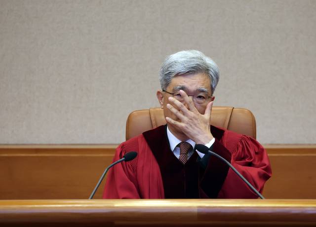 김상환 헌법재판소장이 지난 5월 21일 서울 종로구 헌법재판소 심판정에서 열린 아동ㆍ청소년의 성보호에 관한 법률 제18조 위헌제청 선고에서 안경을 고쳐쓰고 있다. [연합뉴스]