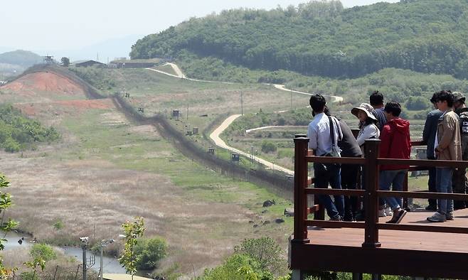 시민들이 강원도 철원군 ‘디엠제트(DMZ) 평화의 길’ 내 공작새 능선 조망대에 올라 철책선 너머 비무장지대를 바라보고 있다. 사진공동취재단