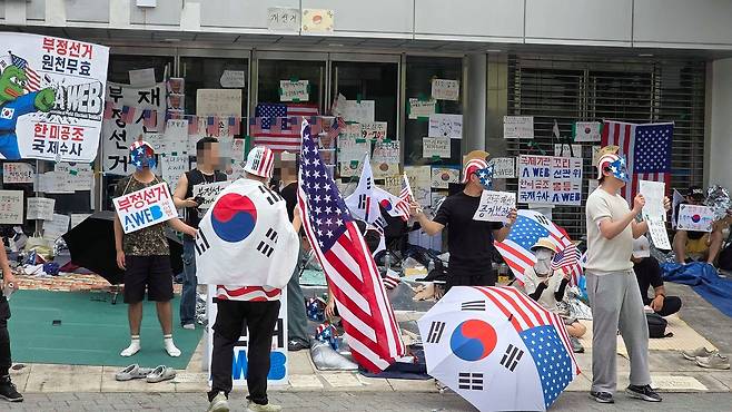17일 오전 잠실 올림픽공원 핸드볼경기장 2-1 출입구 앞에 청년들이 성조기 문양의 로마 병정 투구를 쓰고 부정선거를 주장하고 있다. 한미공조 국제수사 등 문구가 쓰인 패널도 붙었다. 김창용 기자
