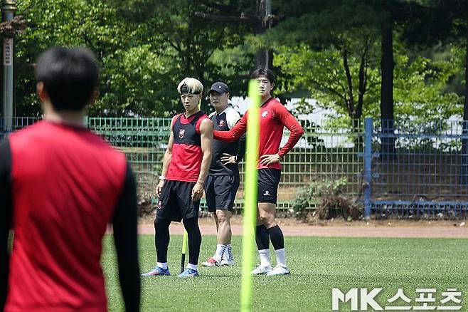 훈련장에서 코칭스태프의 설명을 듣고 있는 카즈(사진 왼쪽). 사진=이근승 기자