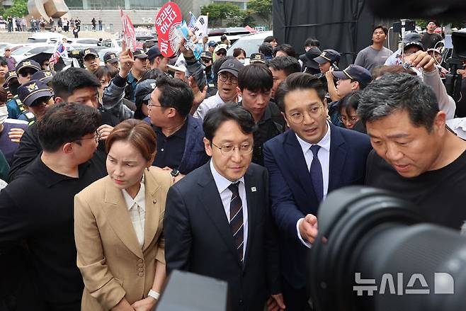 [서울=뉴시스] 권창회 기자 = 천준호, 임오경, 전용기 더불어민주당 의원들이 17일 6·3 지방선거 투표용지 부족 사태에 반발한 시민들이 시위를 이어가고 있는 서울 올림픽공원 핸드볼경기장을 찾아 현장을 둘러보다 시위대의 항의를 받고 발길을 돌리고 있다. 2026.06.17. kch0523@newsis.com