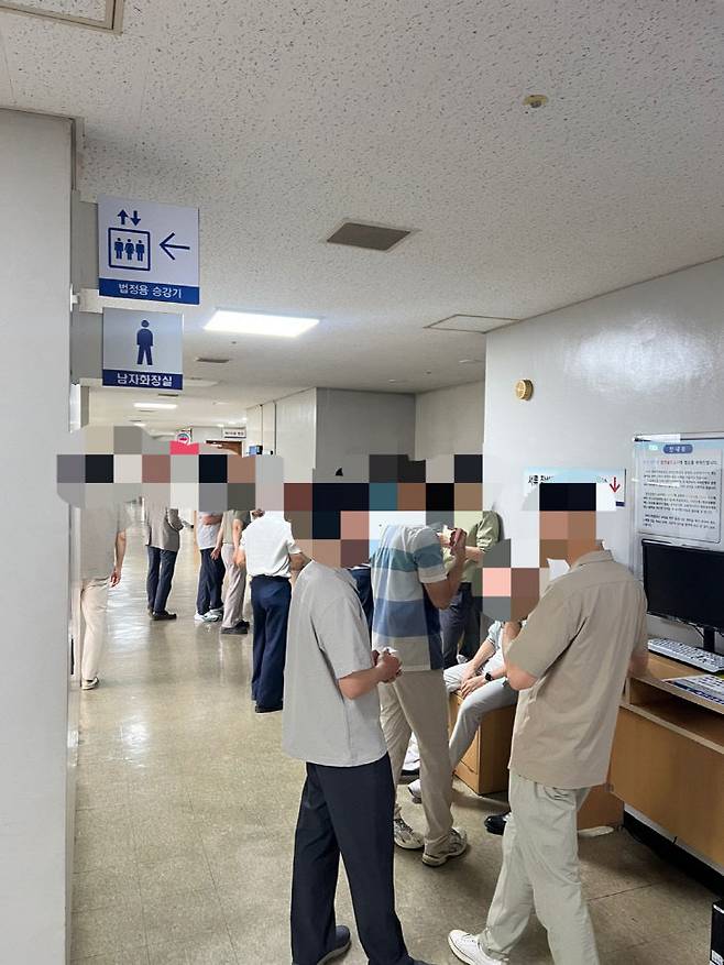 18일 열린 정명석 씨의 먹는물관리법 위반 혐의 첫 공판에 신도로 보이는 남성들이 줄을 서서 재판정 입장을 기다리고 있다. (사진=이현제 기자)