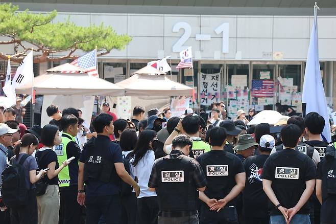 6·3 지방선거 ‘투표용지 부족 사태’로 12일째 잠실 개표소 봉쇄 시위가 이어지고 있는 16일 경찰과 대한체육회 등관계자들이 서울 송파구 올림픽공원 핸드볼경기장 진입을 시도하다 시위대와 대치하고 있다. 2026.6.16 뉴스1