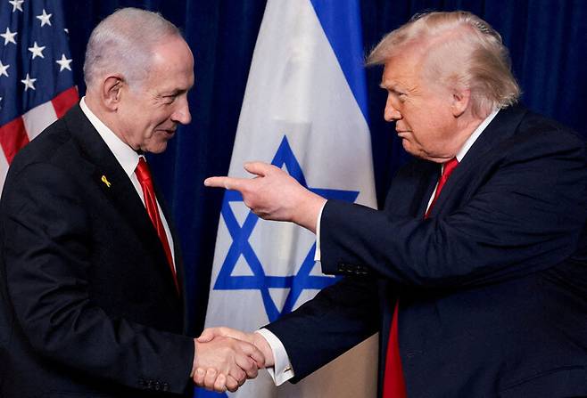 지난해 12월말 도널드 트럼프 미국 대통령(오른쪽)이 베냐민 네타냐후 이스라엘 총리와 미국 플로리다주 팜비치의 마러라고 리조트에서 회담을 나눈 뒤 기자회견에서 악수하며 손가락으로 가리키고 있다. 로이터 연합뉴스