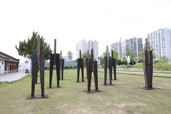 차량정비고에서 열리는 ‘광장의 기억’ 전시는 이우성의 대형 천 회화가 걸개그림처럼 걸리고, 서용선의 회화와 이동욱의 인체 조각이 함께 배치돼 역사와 사회적 기억, 개인과 공동체의 서사를 한 공간에 펼쳐낸다. 진주시 제공