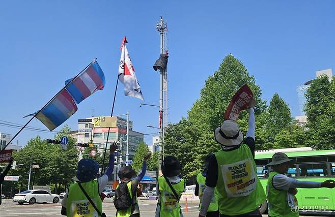 민주노총 공공운수노조 택시지부원들이 18일 오전 택시기사 처우개선을 요구하는 행진에 앞서 고공농성 중인 고영기 전북지회 대림교통분회장에게 인사하고 있다. 박기웅기자