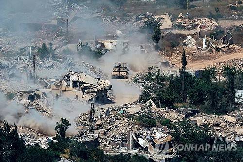 레바논 남부의 붕괴한 마을 사이로 달리는 이스라엘군의 메르카바 탱크 [AFP 연합뉴스. 재판매 및 DB 금지]