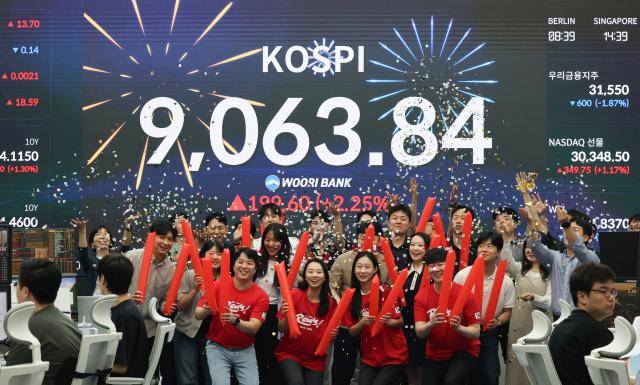 코스피가 사상 처음으로 종가 기준 9,000선을 돌파하며 장을 마친 18일 서울 중구 우리은행 본점 딜링룸에서 직원들이 축하 세리머니를 하고 있다. [사진=연합뉴스]