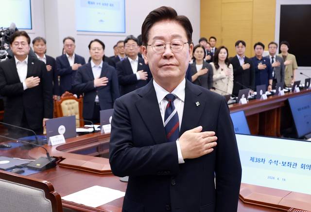이재명 대통령이 19일 청와대에서 열린 수석보좌관회의에서 국기에 경례하고 있다. [연합뉴스]