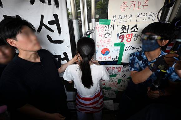 6·3 지방선거 투표용지 부족 사태로 시작한 서울 송파구 올림픽공원 핸드볼경기장 일대 '개표소 봉쇄 시위'가 이어지는 가운데 16일 한 시위 참가자가 대한체육회 등 입주 단체 관계자들의 진입을 막아서고 있다. 2026.6.16 [사진=연합뉴스]