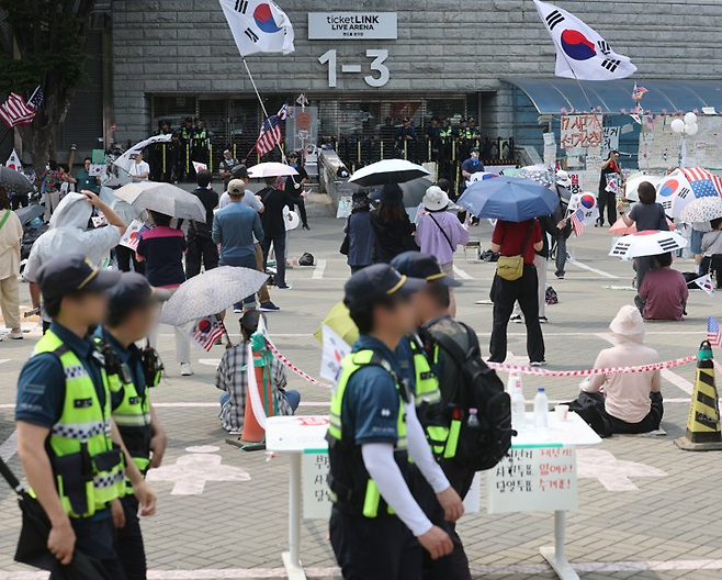 6·3 지방선거 투표용지 부족 사태로 인한 ‘개표소 봉쇄 시위’가 계속되고 있는 19일 서울 송파구 올림픽공원 핸드볼경기장 출입문 앞에서 참가자들이 구호를 외치고 있다. [연합]