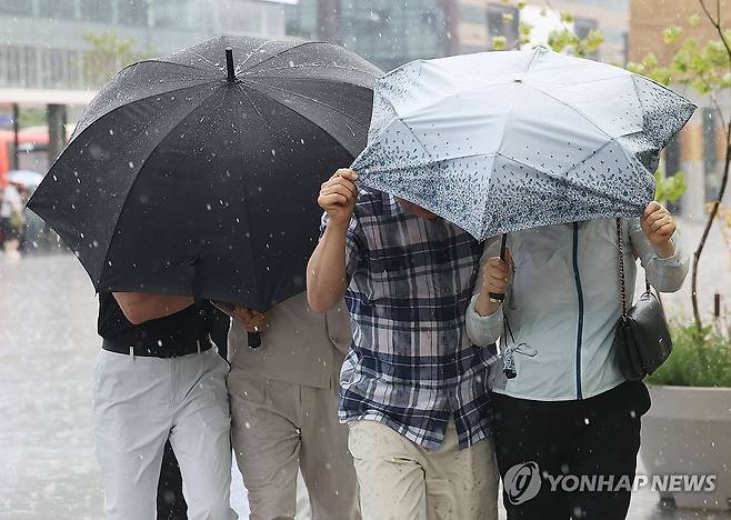 '강풍을 동반한 비' (서울=연합뉴스) 한종찬 기자 = 소나기가 내린 14일 서울 종로구 광화문광장에서  시민들이 우산으로 바람과 비를 막고 있다 . 2026.6.14 saba@yna.co.kr