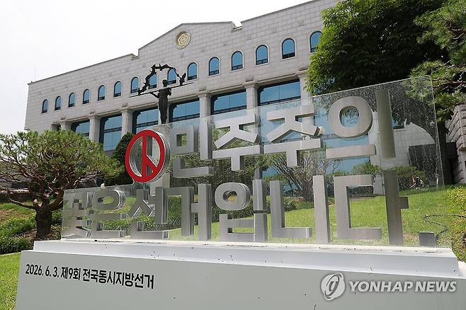 '민주주의 꽃은 선거' (과천=연합뉴스) 김성민 기자 = '투표용지 부족사태 진상규명위원회 제7차 위원회의'가 열린 18일 경기도 과천시 중앙선거관리위원회에 선거 관련 조형물이 놓여 있다.  2026.6.18 ksm7976@yna.co.kr