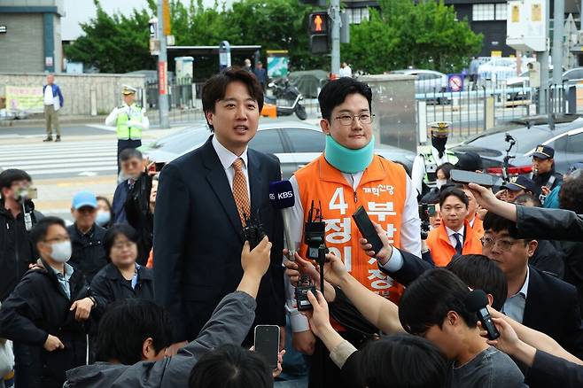 이준석 개혁신당 대표(왼쪽)와 정이한 개혁신당 부산시장 후보가 4월29일 부산 북구 구포시장을 찾아 발언하고 있다. 정이한 후보는 전날 시민이 던진 음료수를 피하다 다쳐 석고붕대를 하고 있다. ⓒ연합뉴스