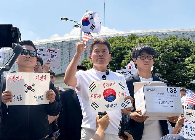 전 한국사 강사 전한길씨와 전씨의 지지자들이 6월 12일 개표소 봉쇄 시위 현장인 서울 송파구 SK핸드볼경기장 앞에서 잠실7동 제2투표소에 보관돼 있다 사라진 투표용지 보관상자 중 1개를 제보를 통해 확보했다고 주장하며 상자를 공개하고 있다. 연합뉴스