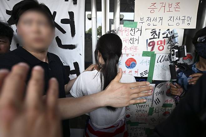 지난 16일 서울 올림픽공원 핸드볼경기장에서 한 시위 참가자가 문 손잡이를 잡은 채 대한체육회 등 입주 단체 관계자들의 진입을 막고 있다. /사진=뉴스1