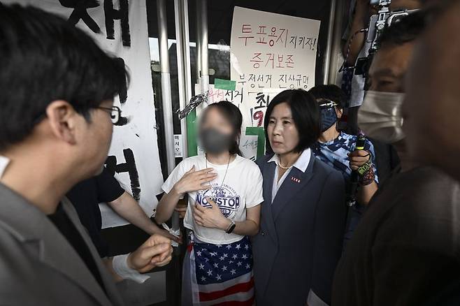 국민의힘 당직자들이 지난 16일 서울 올림픽공원 핸드볼경기장에서 대한체육회 등 입주 단체 관계자들의 진입을 막아선 한 시위 참가자와 대화를 시도하고 있다. /사진=뉴스1