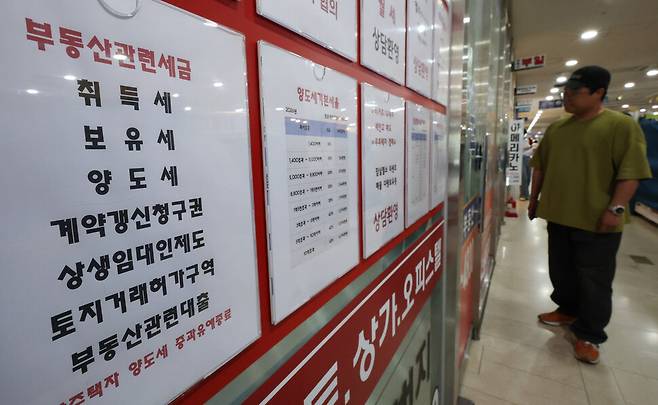 지난 21일 서울 송파구 한 부동산 중개업소에 부동산 관련 세금 안내문이 붙어 있다. 연합뉴스