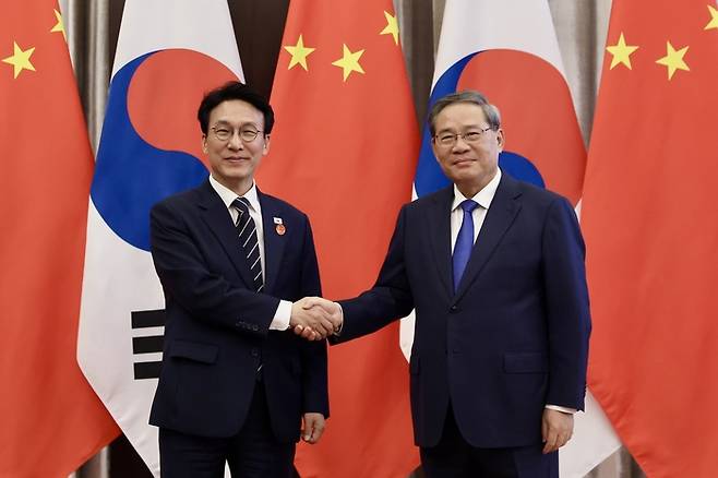 중국을 방문 중인 김민석 국무총리가 23일 중국 다롄의 방추도 호텔에서 리창 국무원 총리를 만나 회담에 앞서 악수하고 있다. [국무총리실, 연합뉴스]