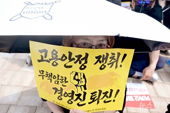 지난 10일 경기 성남시 유스페이스 야외광장에서 열린 민주노총 전국화학섬유식품산업노동조합 카카오지회의 2026 임단협 승리 결의대회 중 한 노조원이 '고용안전 쟁취, 무책임한 경영진 퇴진' 문구가 적힌 손팻말을 들고 있다. 사진=강민석 기자
