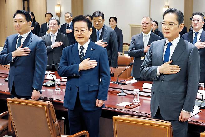 2025년 11월 16일 서울 용산 대통령실에서 열린 한미 관세협상 후속 민관 합동회의에 앞서 이재명 대통령(앞줄 가운데)과 참석자들이 국기에 대한 경례를 하고 있다. 앞줄 왼쪽부터 최태원 SK그룹 회장, 이 대통령, 이재용 삼성전자 회장. 뒷줄 왼쪽부터 김용범 대통령실 정책실장, 서정진 셀트리온 회장, 정의선 현대차그룹 회장, 구광모 LG그룹 회장. /연합뉴스