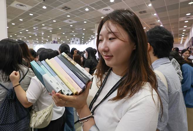 24일 오전 서울 강남구 코엑스에서 열린 2026 서울국제도서전에서 한 시민이 본인이 구매한 책을 보이고 있다. 2026.6.24 /박성원 기자