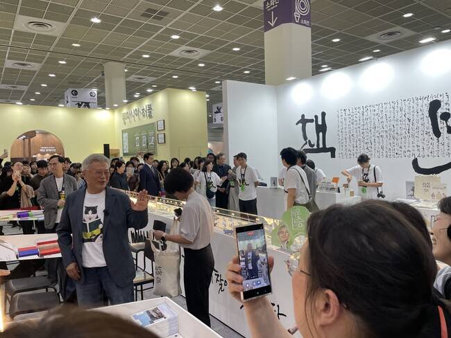 25일 오후 평산책방×돌베개 부스에 들른 문재인 전 대통령. 관객들이 이름을 부르자 돌아보며 손을 흔들고 있다. 이유진 기자
