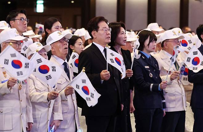6·25전쟁 기념식 찾은 李대통령 이재명 대통령과 김혜경 여사가 25일 경기도 수원시 영통구 수원컨벤션센터에서 열린 6·25전쟁 제76주년 기념식에서 '6·25의 노래'를 제창하며 태극기를 흔들고 있다.  김호영 기자