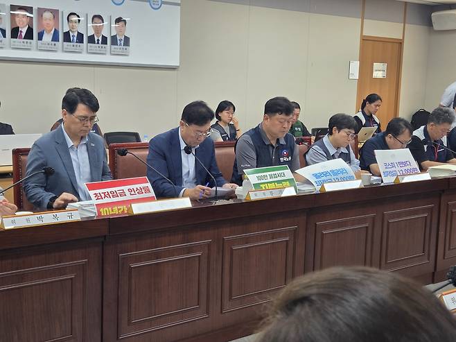 류기정 한국경영자총협회 전무(왼쪽 두번째)와 류기섭 한국노총 사무총장(왼쪽 세번쩨) 등 최저임금위원회 위원들이 25일 정부세종청사에서 열린 최저임금위원회 제9차 전원회의에 참석해 회의 자료를 검토하고 있다. 노동계와 경영계는 이날 내년도 최저임금 수준을 둘러싼 첫 조정 협상을 진행했다. [사진=김용훈 기자]