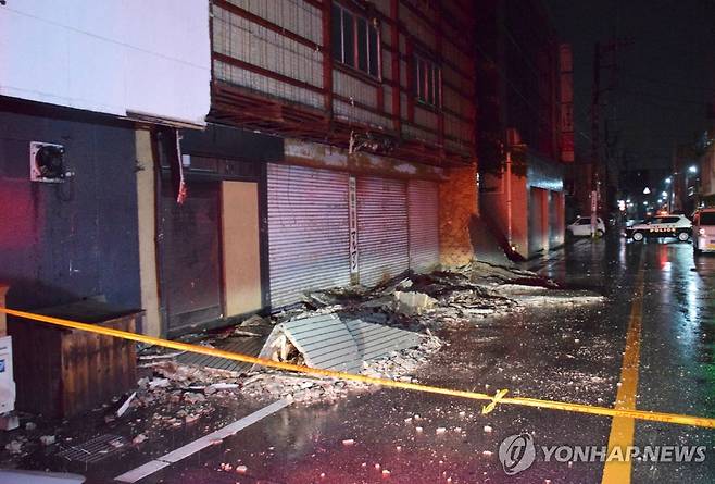 26일 밤 지진으로 무너진 야마나시현 고후시 건물 외벽 [지지통신 제공. AFP=연합뉴스]