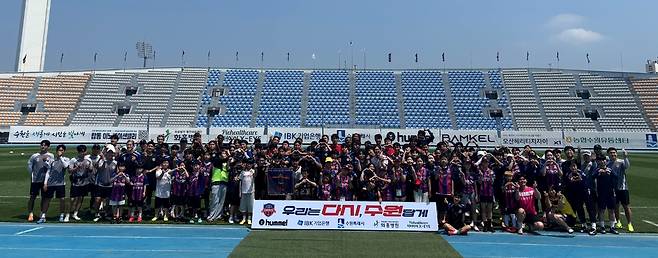 28일 수원종합운동장에서 열린 '2026 수원FC 오픈 트레이닝' 데이'에서 워밍업 프로그램에 참여한 팬들과 남녀팀 선수단이 함께 기념촬영을 하고 있다.