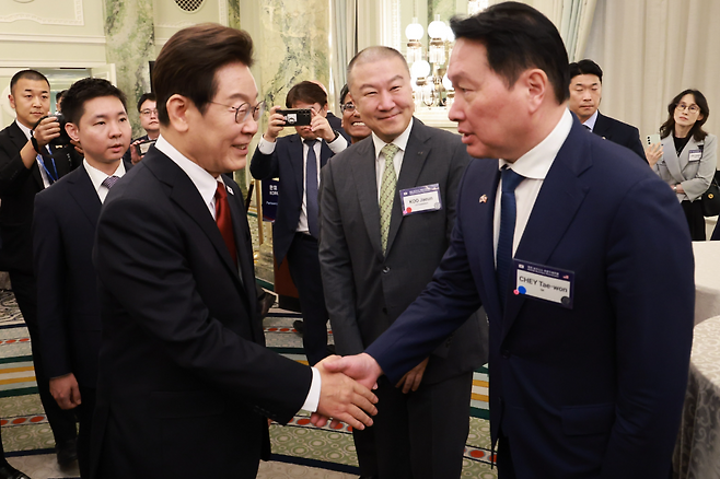 이재명 대통령이 지난 25일(현지시간) 미국 워싱턴DC 윌라드 호텔에서 열린 한미 비즈니스 라운드 테이블에서 최태원 대한상의회장 겸 SK그룹 회장과 악수하고 있다. 가운데는 구자은 LS 회장. 연합뉴스