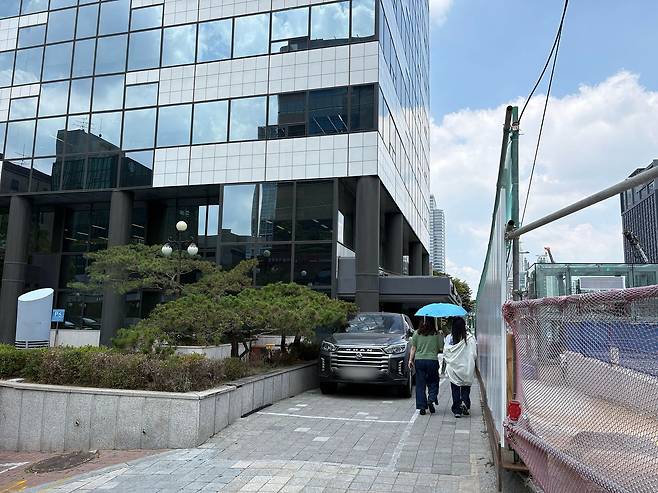 23일 수도권광역급행철도(GTX)-A 노선 공사가 진행 중인 서울 강남구 삼성역 3번 출구 앞. A빌딩 앞 주차된 승용차와 공사장 펜스 사이를 보행자 2명이 지나가고 있다. 김예정 기자
