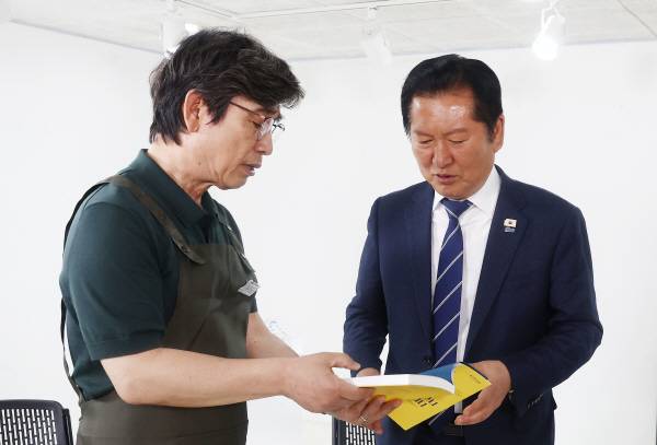 더불어민주당 정청래 대표가 24일 서울 성동구 언더스탠드에비뉴에 마련된 청각장애인 수제화 브랜드 ‘아지오’ 매장 오픈 행사에 참석, 유시민 작가로부터 책을 전달받고 있다. 2026.4.24 [공동취재]