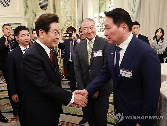 이재명 대통령, 최태원 회장과 악수 (워싱턴=연합뉴스) 홍해인 기자 = 이재명 대통령이 25일(현지시간) 미국 워싱턴DC 윌라드 호텔에서 열린 한미 비즈니스 라운드 테이블에서 최태원 대한상의회장 겸 SK그룹 회장과 악수하고 있다. 가운데는 구자은 LS 회장.  2025.8.26 hihong@yna.co.kr