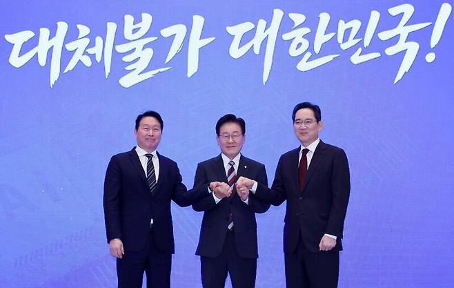 이재명 대통령(가운데)이 29일 청와대에서 열린 ‘대한민국 대도약 3대 메가프로젝트 국민보고회’에서 최태원 에스케이(SK)그룹 회장(왼쪽)과 이재용 삼성전자 회장과 함께 손을 맞잡고 있다. 청와대사진기자단