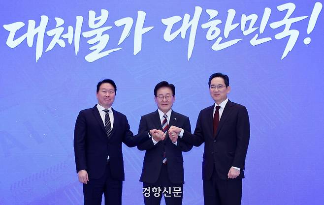이재명 대통령이 29일 청와대에서 열린 ‘대한민국 대도약 3대 메가프로젝트 국민보고회’에서 최태원 SK그룹 회장과 이재용 삼성전자 회장과 함께 손을 맞잡고 있다. 청와대사진기자단