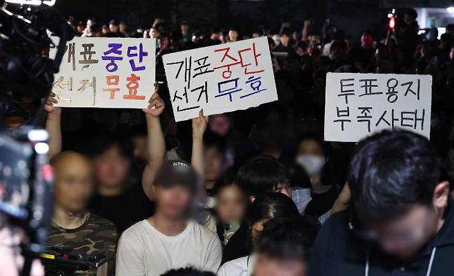 4일 제9회 전국동시지방선거 및 국회의원 재·보궐선거 투표용지 부족으로 투표 시간이 오후 10시까지 연장됐던 서울 송파구 잠실7동 제2투표소 앞에서 '부정선거' 등 손팻말을 든 시민들이 구호를 외치고 있다. 연합뉴스