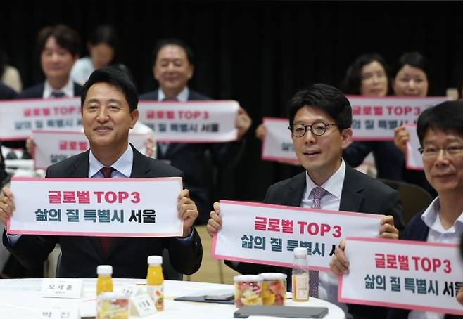오세훈(왼쪽 첫 번째) 서울시장과 김병민(가운데) G3 서울 기획위원회 공동위원장이 29일 시청에서 열린 G3 서울 기획위원회 발대식에서 ‘글로벌 탑3 삶의 질 특별시 서울’이라고 적힌 타올을 펼쳐 드는 퍼포먼스를 하고 있다. 연합뉴스
