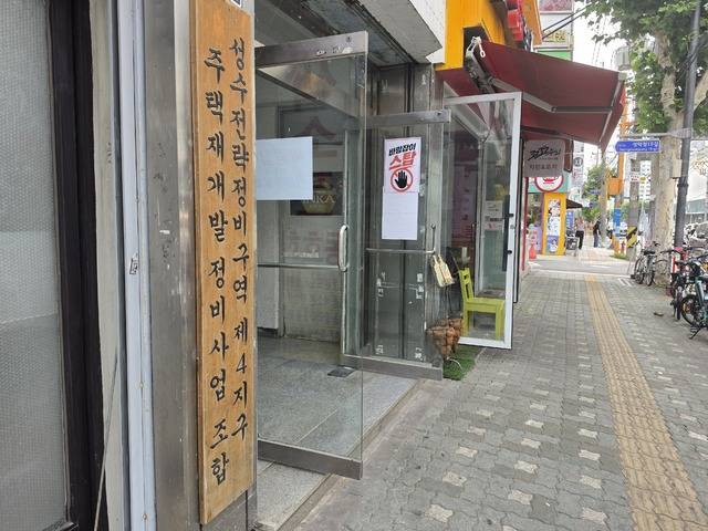 30일 성수4지구 조합사무실 건물 입구에는 ‘바람잡이 STOP’, ‘바람잡이 때문에 바람 잘 날 없다’ 등의 안내문이 부착돼 있었다. 롯데건설·대우건설의 홍보관은 해당 건물 2층에서 운영되고 있다. (사진=박유진 기자)