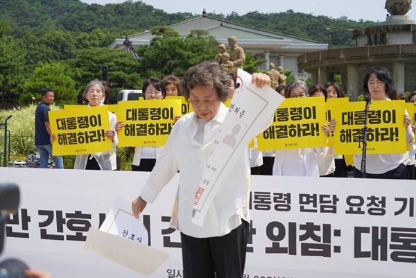 신경림 대한간호협회 회장이 30일 서울 청와대 분수대 앞에서 열린 기자회견에서 대형 간호사 면허증 모형을 찢는 퍼포먼스를 하고 있다. (간협 제공)