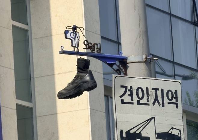 30일 광주 동구 대인동의 한 교차로에 설치된 오월길을 안내하는 표지판에 군화가 걸려 있다./사진=뉴스1