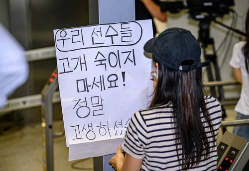 한 축구팬이 30일 오전 한국 축구대표팀의 귀국 현장을 찾아 응원 피켓을 만들고 있다. 박윤슬 기자
