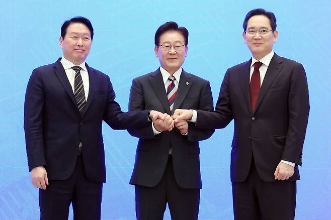 이재명 대통령과 이재용(오른쪽) 삼성전자 회장, 최태원(왼쪽) SK그룹 회장이 29일 청와대에서 열린 3대 메가프로젝트 국민보고회에서 기업 투자계획 발표 후 손을 잡고 있다. 연합뉴스