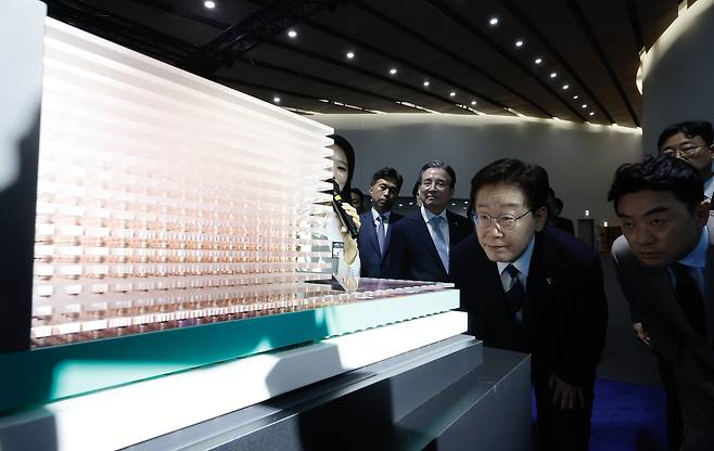 이재명 대통령이 30일 광주 서구 김대중컨벤션센터에서 열린 ‘서남권 첨단산업 발전 비전 국민보고회’에 앞서 SK그룹의 인공지능(AI) 반도체 전시물을 관람하고 있다.  청와대사진기자단