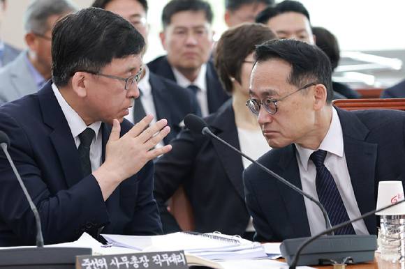 중앙선거관리위원회 사무총장 직무대리인 강동완 사무차장과 허철훈 전 중앙선거관리위원회 사무총장(왼쪽)이 1일 국회에서 열린 '제9회 전국동시지방선거 투표용지 부족 사태 등 국민 참정권 침해 진상규명 및 선거관리 개혁을 위한 국정조사 특별위원회' 제3차 전체회의에서 대화하고 있다. 2026.7.1 [사진=연합뉴스]