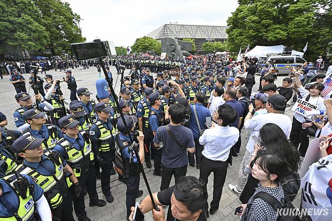 2일 서울 송파구 올림픽공원 핸드볼경기장 출입구에서 경찰과 개표소 봉쇄 시위 참가자들이 대치하고 있다.