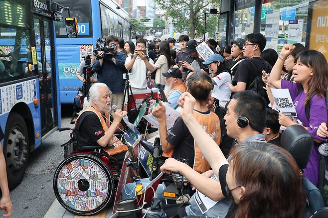전국장애인차별철폐연대(전장연) 회원이 어제(1일) 서울 종로구 혜화동로터리 버스정류장에서 열린 출근길 버스 탑승 시위에서 교통약자이동권보장법 전면 개정을 촉구하고 있다. / 사진=연합뉴스