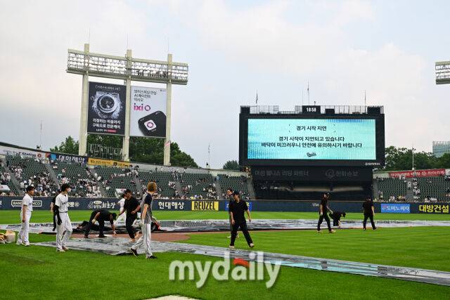 2일 서울 잠실야구장에서 열린 '2026 신한 SOL KBO리그' 롯데 자이언츠와 두산 베어스 경기.경기 재개를 위해 방수포를 치우고 있다.